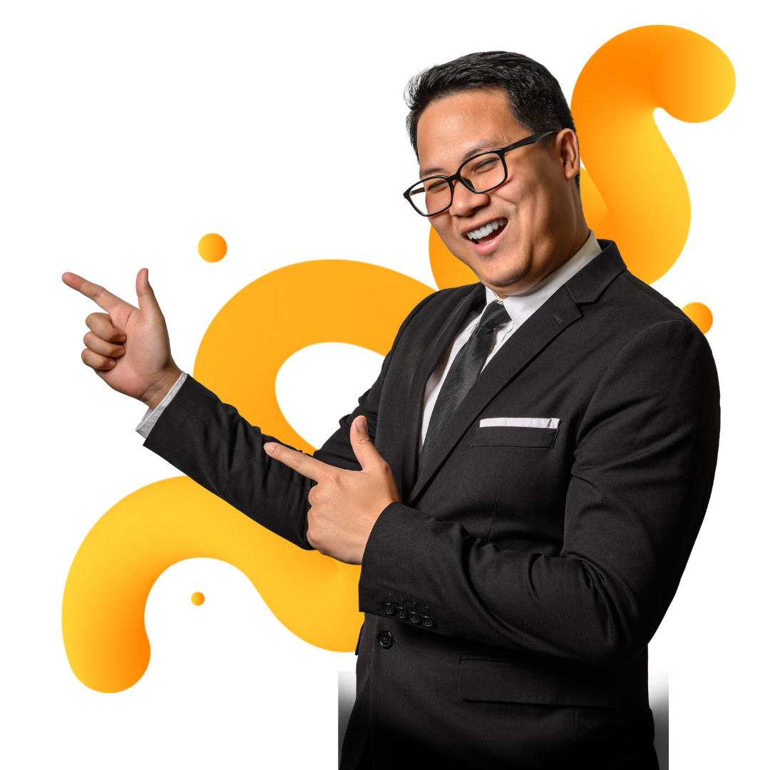 A man in a black suit and glasses smiles and points with both hands. There are abstract yellow-orange shapes in the background.