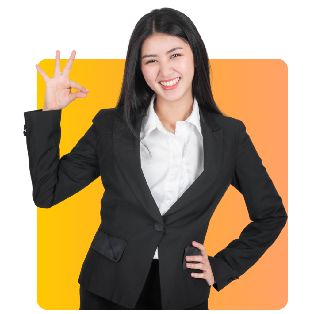 A woman in a black suit and white shirt smiles confidently while making an OK hand gesture, standing in front of a yellow-to-orange gradient background.