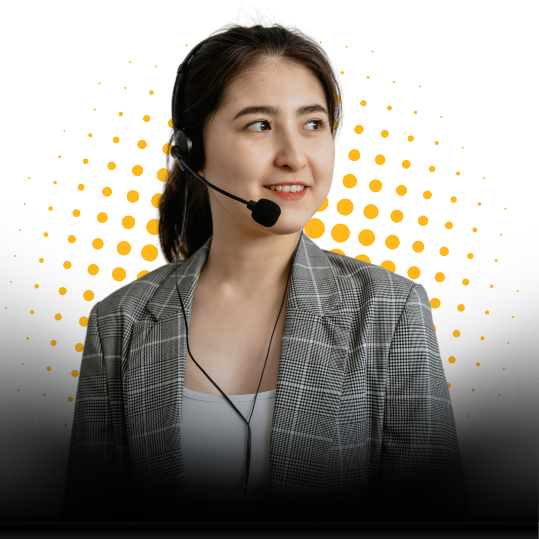 A woman wearing a headset and a gray plaid blazer smiles while looking to the side, standing in front of a background with yellow dots radiating outward.