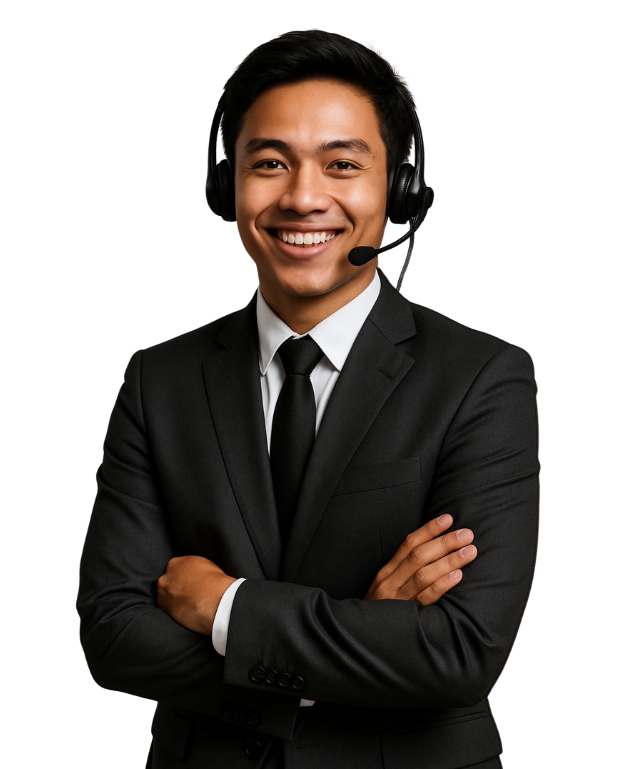 A young man in a black suit and tie, wearing a headset with a microphone, stands with his arms crossed and smiles confidently at the camera.